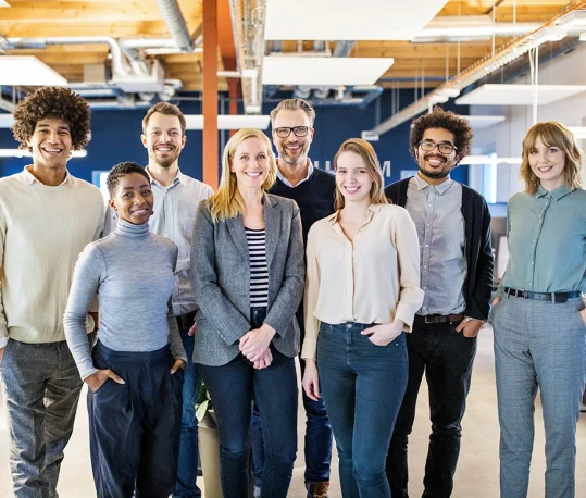 a group of people posing for a picture in an office